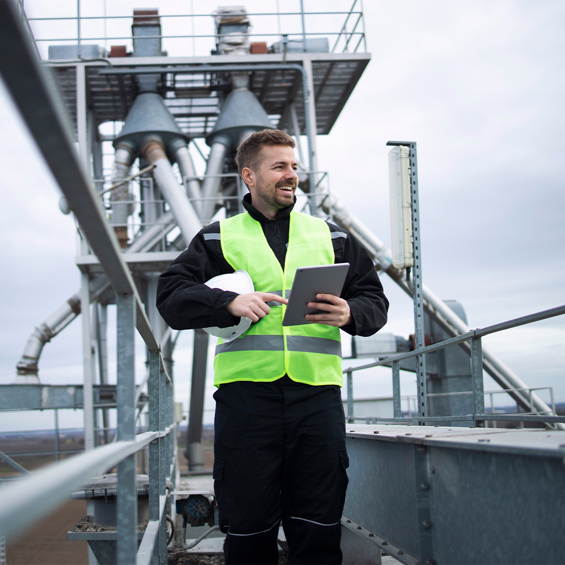 Engineer monitoring a sewage treatment plant using tablet for real-time control and compliance.