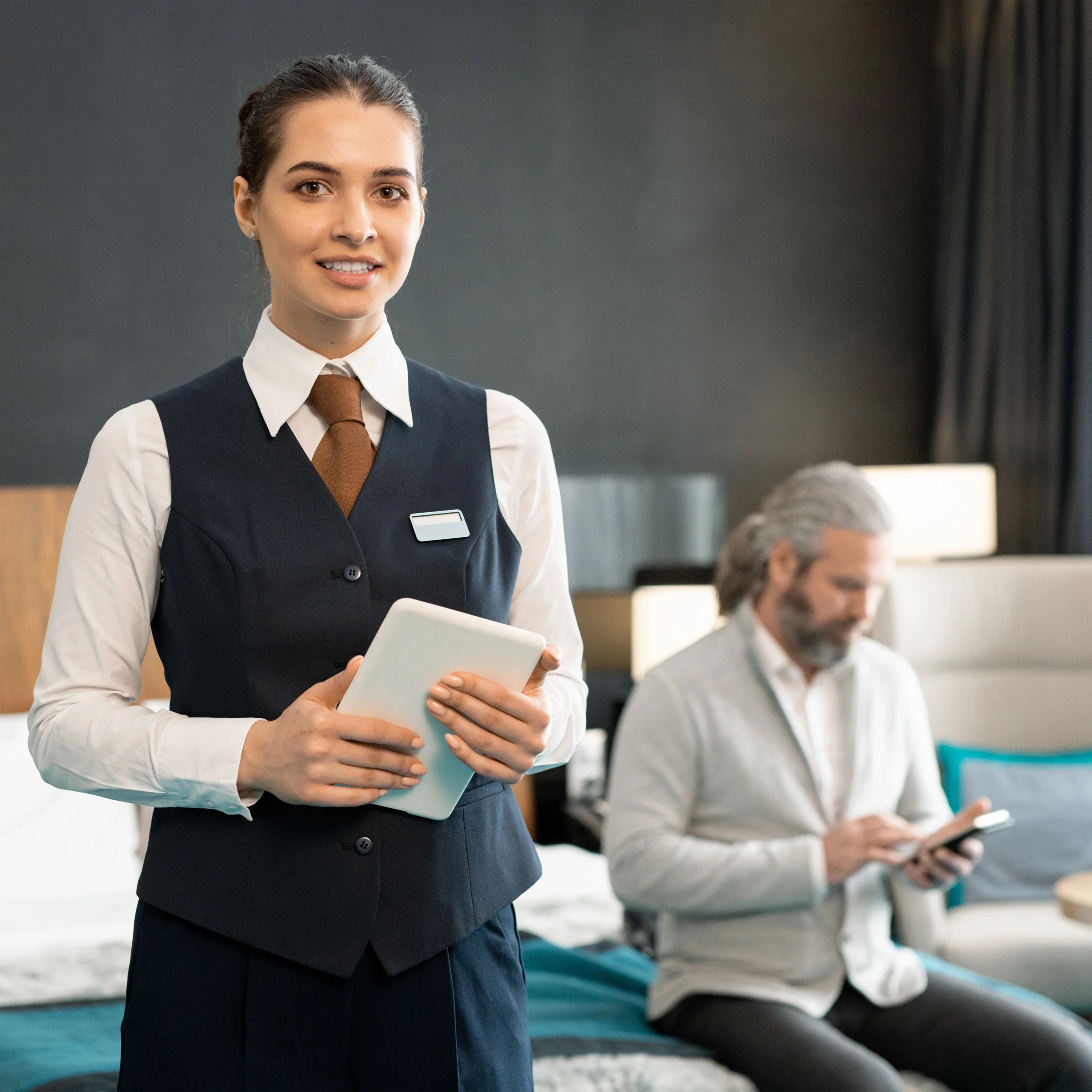 Hotel operations staff using a tablet on which SmarDen's Hotel Automation System is running to make Hotel operations centralized