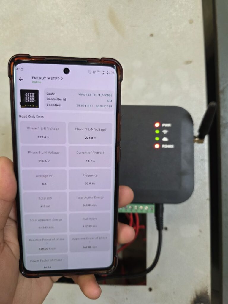 Smartphone displaying real-time energy data from a Modbus energy meter connected to an IoT gateway, powered by SmarDen Prime for industrial machine monitoring
